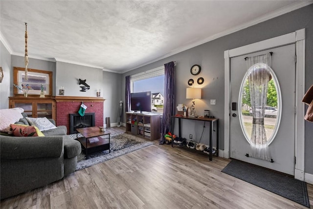 507 2nd St E, Newhall, IA 52315 - living room with wood finished floors, crown molding, a brick fireplace, and baseboards