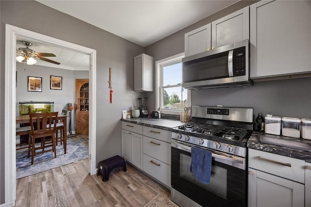 507 2nd St E, Newhall, IA 52315 - kitchen with stainless steel appliances, light wood-style floors, dark countertops, and ceiling fan