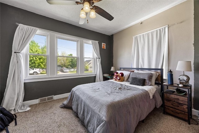 507 2nd St E, Newhall, IA 52315 - carpeted bedroom with multiple windows, a textured ceiling, a ceiling fan, and baseboards