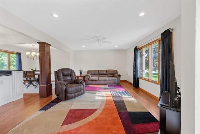 living room with light wood-type flooring, ceiling fan, a chandelier, recessed lighting, and baseboards