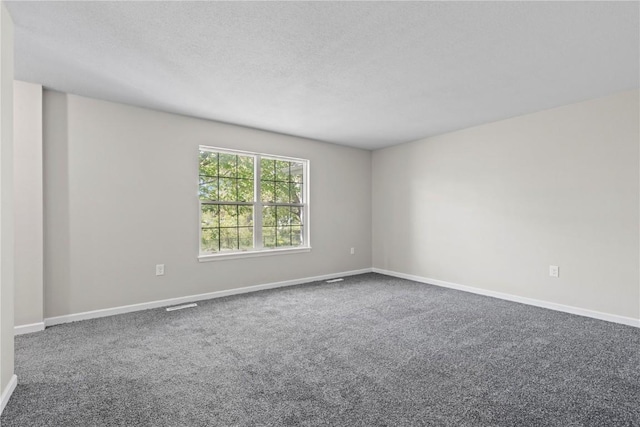 empty room featuring carpet flooring, baseboards, and a textured ceiling