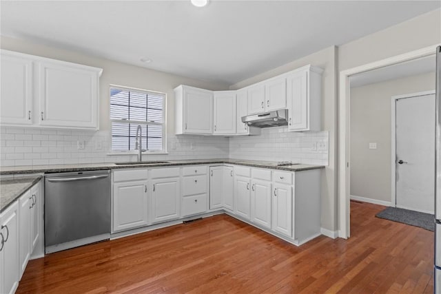 kitchen with stainless steel dishwasher, a sink, under cabinet range hood, white cabinets, and recessed lighting