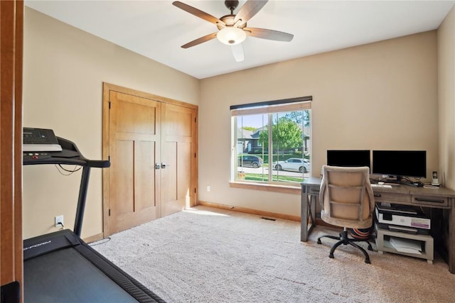 carpeted home office with ceiling fan and baseboards