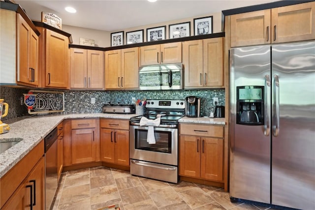 kitchen with appliances with stainless steel finishes, light stone counters, recessed lighting, backsplash, and light stone finish flooring