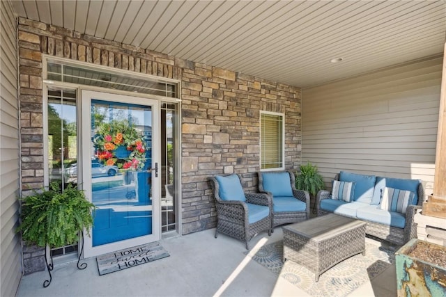 doorway to property with stone siding and outdoor lounge area
