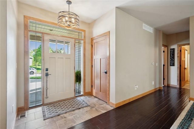 entrance foyer featuring baseboards, a chandelier, and light wood-type flooring