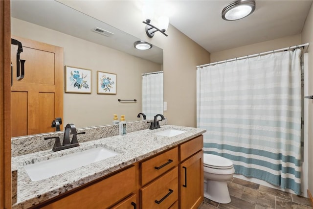 full bathroom with toilet and double vanity