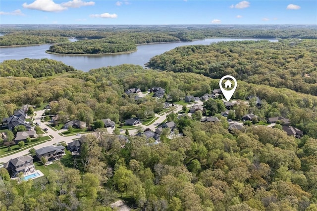 aerial view of residential area with a forest and a nearby body of water
