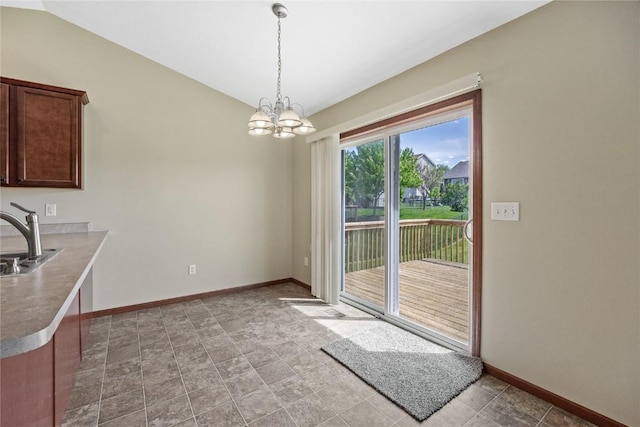 unfurnished dining area featuring a chandelier, baseboards, a sink, and vaulted ceiling