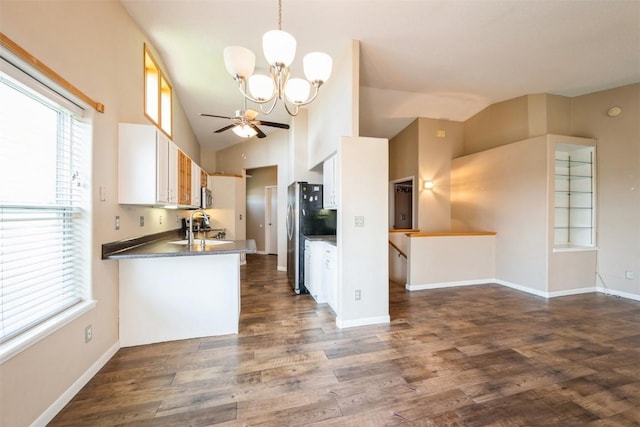 kitchen featuring vaulted ceiling, a chandelier, healthy amount of natural light, dark wood finished floors, and white cabinets