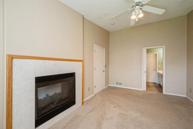 unfurnished living room with a fireplace, carpet flooring, baseboards, and a ceiling fan