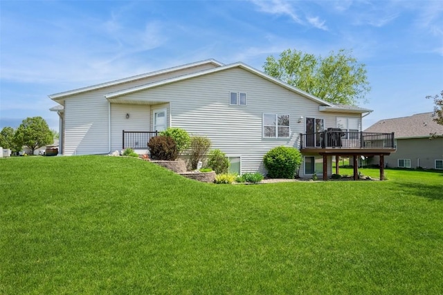 rear view of property featuring a lawn and a wooden deck