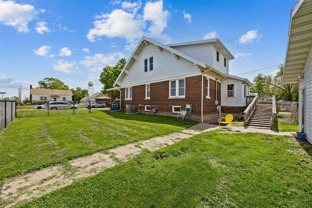 back of house with brick siding, stairs, and central air condition unit
