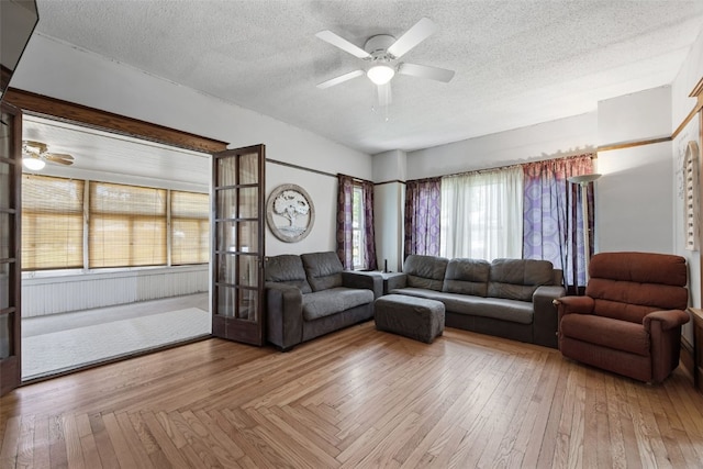 living area featuring a ceiling fan, a textured ceiling, french doors, and hardwood / wood-style flooring