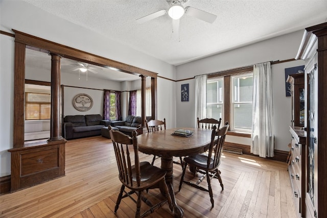 dining room featuring ceiling fan, a textured ceiling, decorative columns, and plenty of natural light