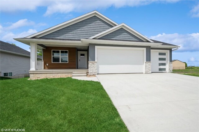 2740 Burns Dr, Marion, IA 52302 - view of front of home with a garage, covered porch, driveway, a front yard, and stone siding