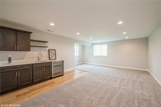 2740 Burns Dr, Marion, IA 52302 - kitchen with wine cooler, a sink, light carpet, dark brown cabinets, and open shelves