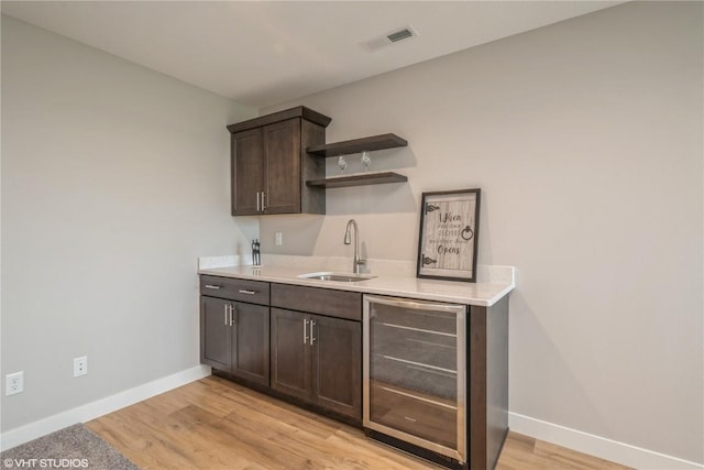 2740 Burns Dr, Marion, IA 52302 - bar with beverage cooler, a sink, baseboards, and light wood finished floors