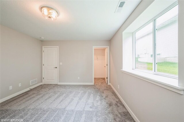 2740 Burns Dr, Marion, IA 52302 - unfurnished bedroom featuring multiple windows, carpet flooring, and a spacious closet