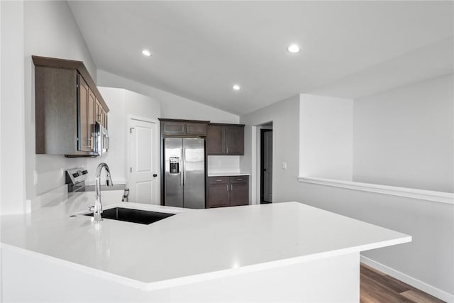 3850 Quail Trail Dr, Marion, IA 52302 - kitchen featuring stainless steel appliances, a sink, vaulted ceiling, light countertops, and dark brown cabinetry