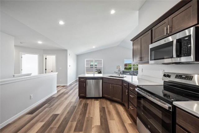3850 Quail Trail Dr, Marion, IA 52302 - kitchen with appliances with stainless steel finishes, a sink, dark brown cabinets, light countertops, and vaulted ceiling