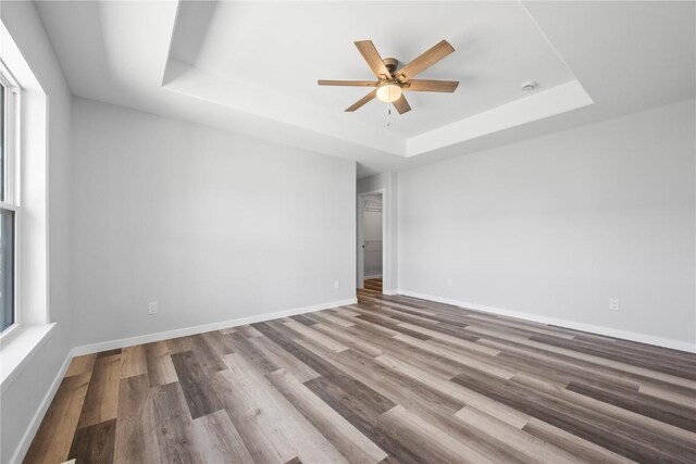 3850 Quail Trail Dr, Marion, IA 52302 - empty room featuring a tray ceiling, wood finished floors, ceiling fan, and baseboards