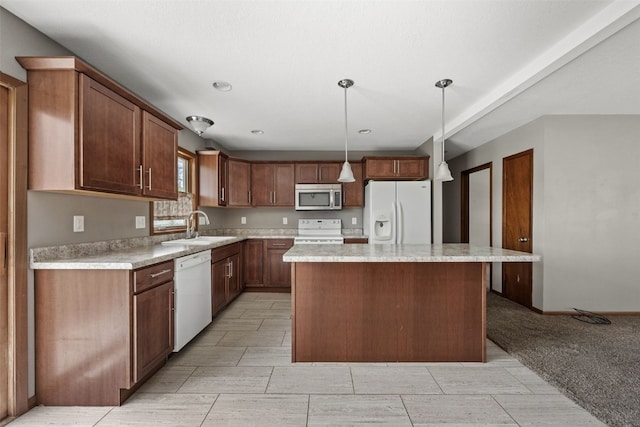 kitchen with white appliances, a sink, light countertops, a kitchen island, and decorative light fixtures