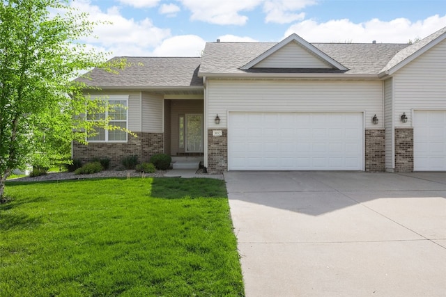 view of front facade with brick siding, a garage, and a front lawn