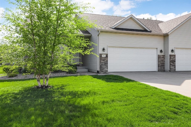 view of front of home featuring brick siding, a front lawn, driveway, and a garage