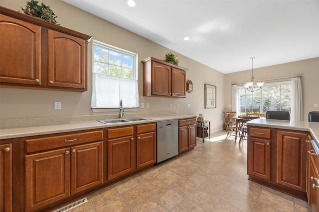 kitchen featuring stainless steel dishwasher, a sink, a chandelier, light countertops, and brown cabinets