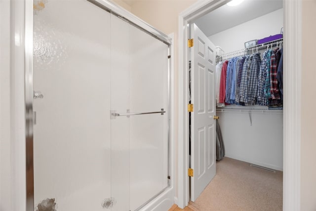 full bath featuring a shower stall and a walk in closet