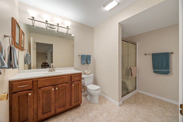 bathroom with a shower stall, toilet, vanity, and baseboards