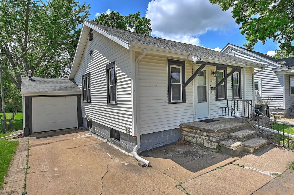 view of front of house featuring driveway, a shingled roof, and a garage