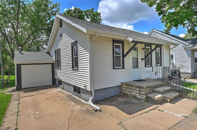 view of front of house featuring driveway, a shingled roof, and a garage