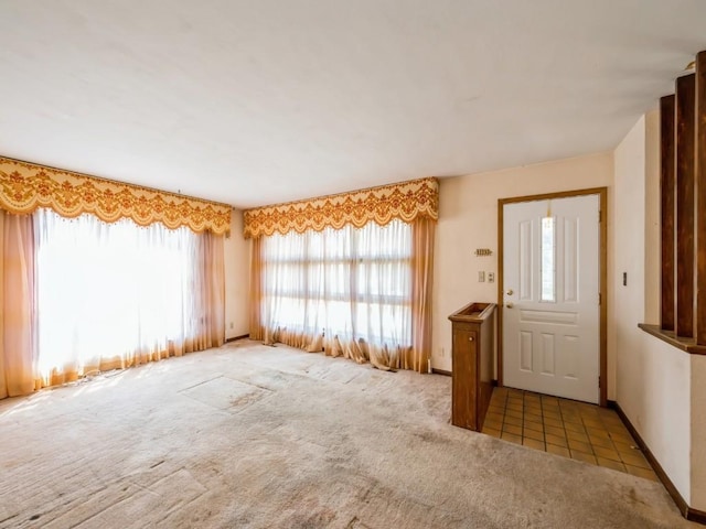 entrance foyer featuring carpet and baseboards