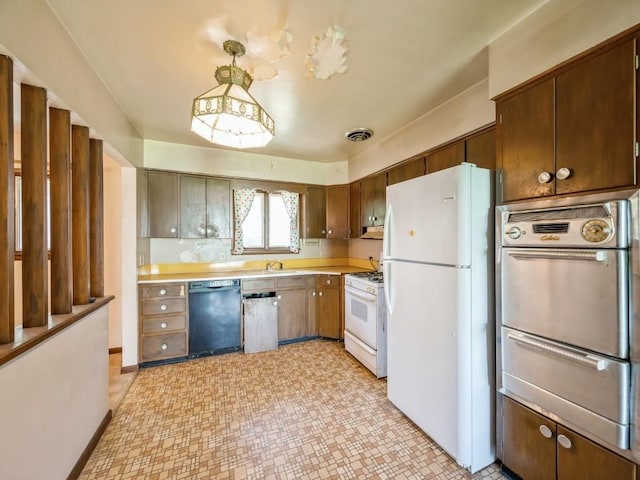 kitchen with white appliances, a warming drawer, light countertops, and a sink