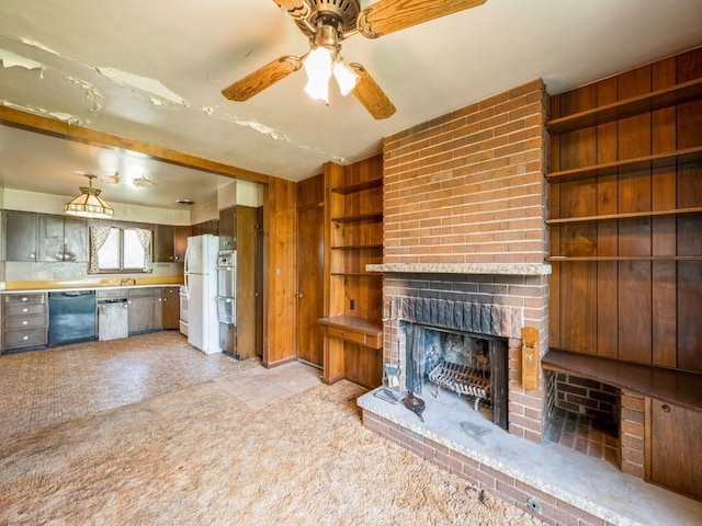 unfurnished living room featuring light colored carpet, a fireplace, ceiling fan, and built in features