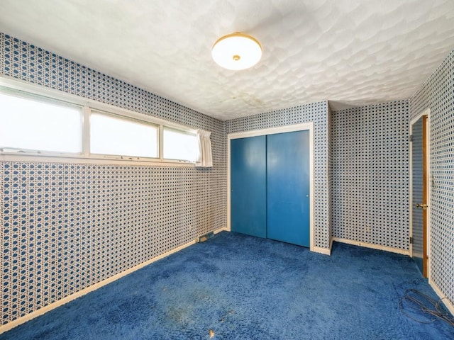 unfurnished bedroom with a closet, carpet flooring, and a textured ceiling
