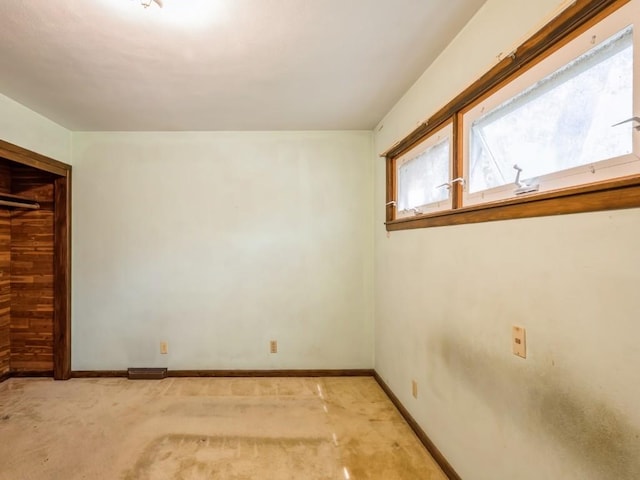unfurnished bedroom with multiple windows, light carpet, and baseboards