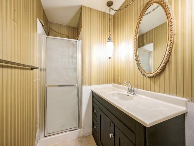 full bathroom featuring a stall shower, wallpapered walls, and vanity