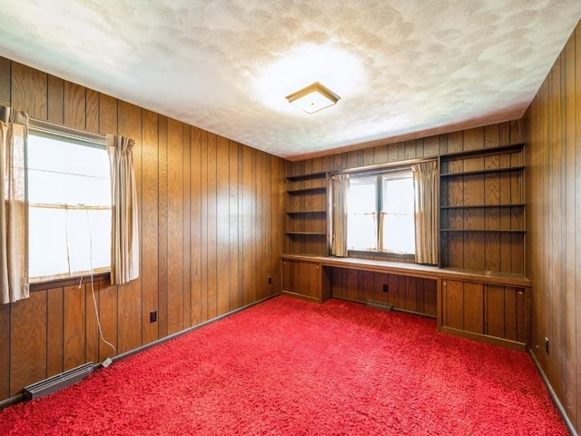 carpeted empty room featuring wooden walls