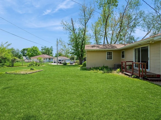 view of green lawn with a deck and cooling unit