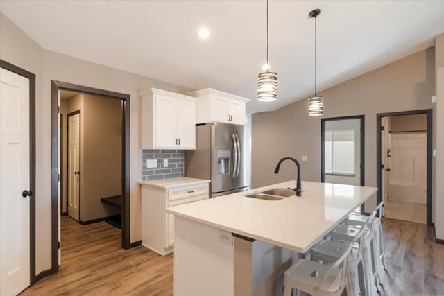 412 Dawson Dr, West Branch, IA 52358 - kitchen with stainless steel refrigerator with ice dispenser, a sink, light wood-type flooring, an island with sink, and white cabinets