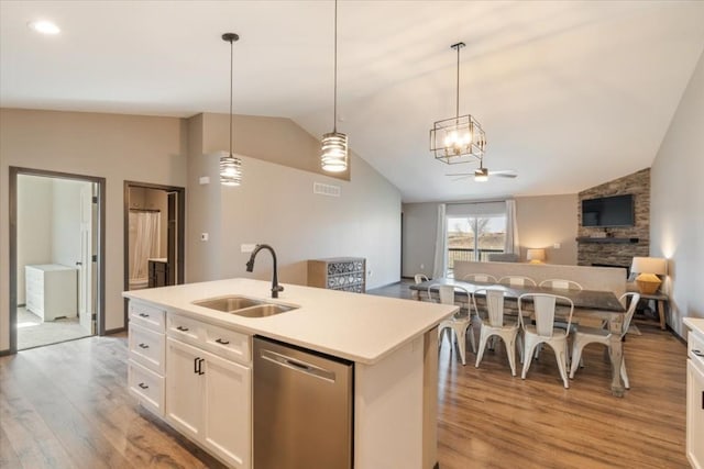 412 Dawson Dr, West Branch, IA 52358 - kitchen with stainless steel dishwasher, a sink, vaulted ceiling, light wood-style floors, and open floor plan