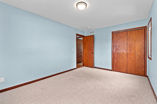 206 Hilltop Rd SW, Swisher, IA 52338 - unfurnished bedroom featuring a textured ceiling, carpet floors, a closet, and baseboards