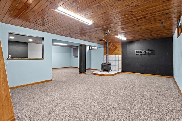 206 Hilltop Rd SW, Swisher, IA 52338 - finished basement with a wood stove, baseboards, carpet floors, and wooden ceiling