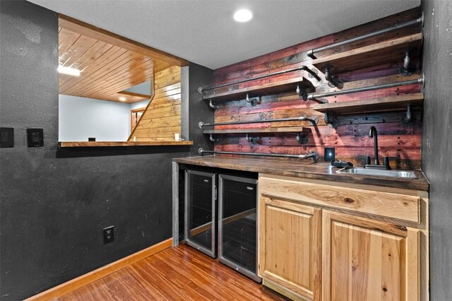 206 Hilltop Rd SW, Swisher, IA 52338 - indoor wet bar featuring wood finished floors, baseboards, and wine cooler