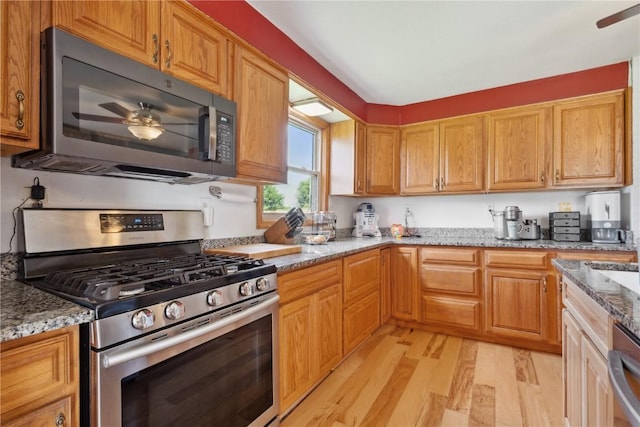 829 Union Ave, Lowden, IA 52255 - kitchen featuring stainless steel appliances, light wood-style floors, a ceiling fan, and light stone countertops