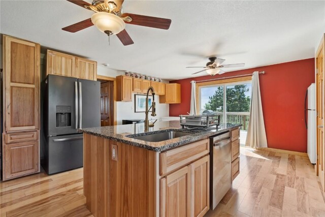 829 Union Ave, Lowden, IA 52255 - kitchen featuring appliances with stainless steel finishes, a sink, an island with sink, a ceiling fan, and light wood-type flooring