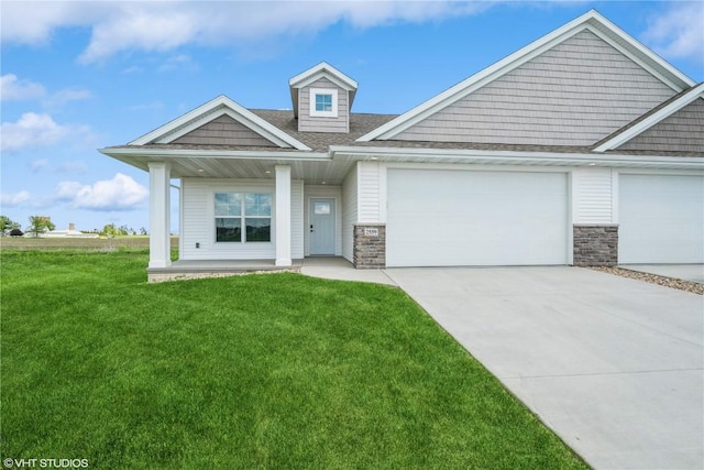 2559 Bluegrass St, Marion, IA 52302 - view of front of home featuring a front yard, driveway, stone siding, an attached garage, and a shingled roof